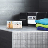 Table clock with vacation motif as a bathroom accessory