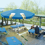 Beer tables with tablecloths, matching the design of the large parasol
