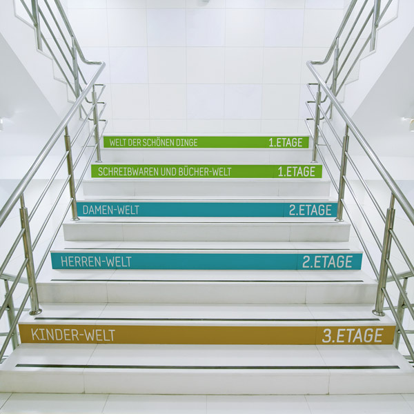 Floor film adhered to stairs for improved orientation at the point of sale.