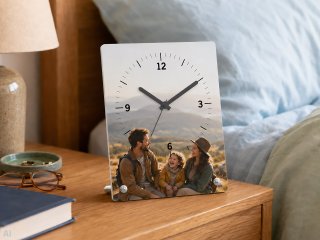 Photo alarm clock with personal family photo on a bedside table